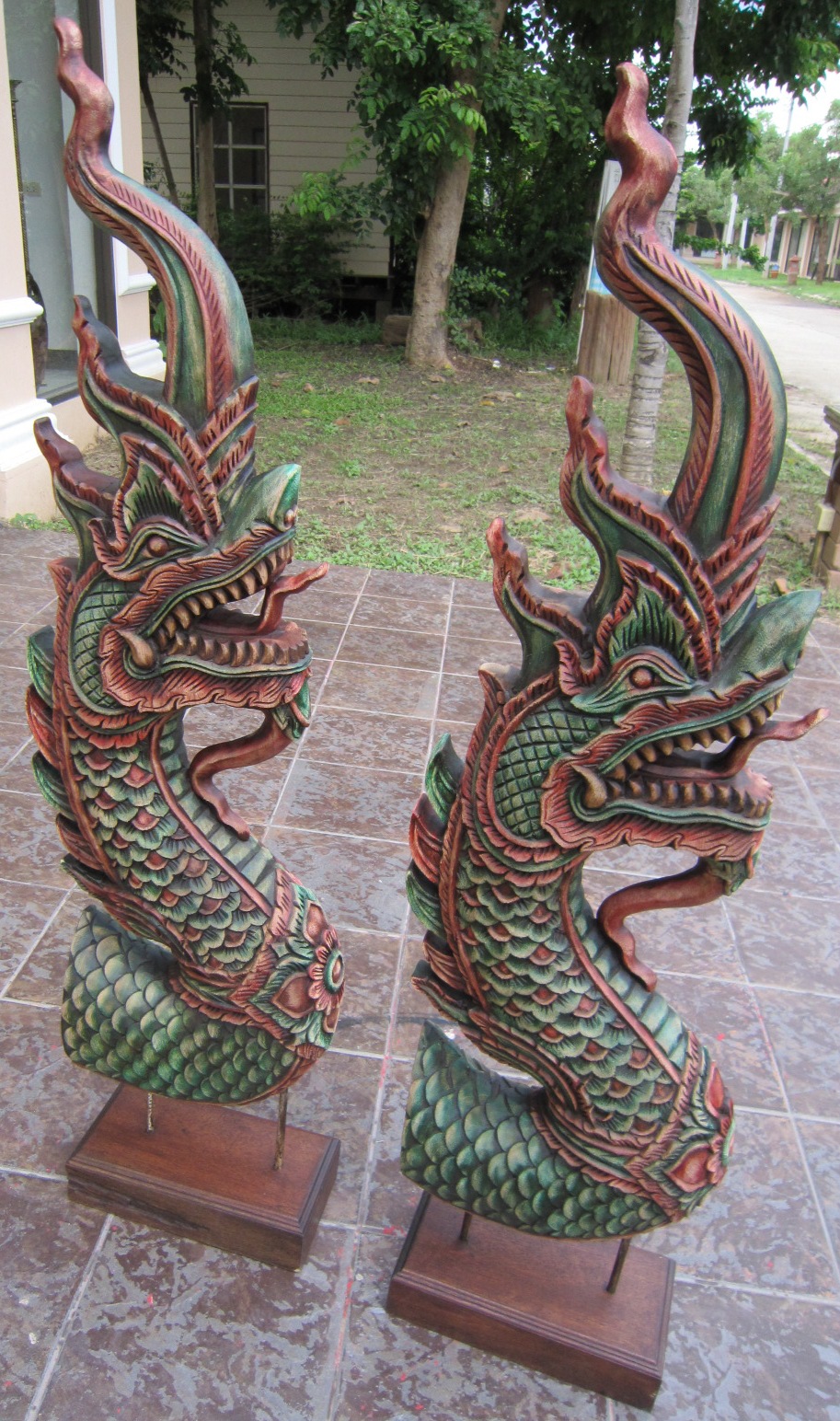 Pair of hand carved naga heads with stands